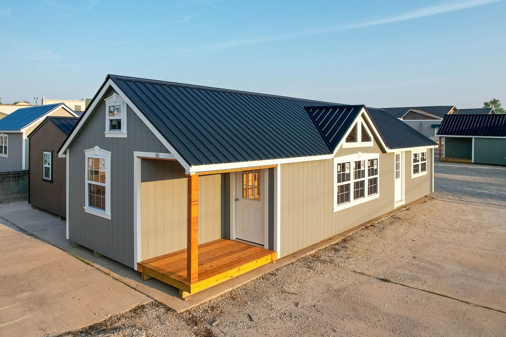 Gray Estate Cabin by 5-Star Buildings with metal roof, front porch, and multiple windows.